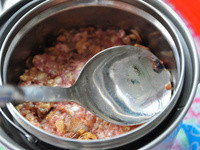 將調味後的絞肉放進大同內鍋中，再將剩餘的米酒倒入鍋中，加上約1大匙素蠔油膏在上層，使用湯匙將絞肉壓平